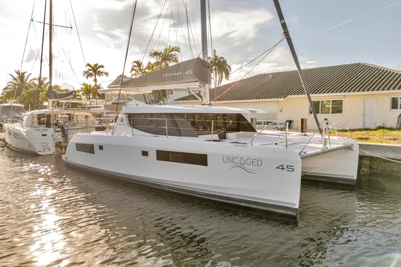  Yacht Photos Pics 2020 Leopard 45 catamaran "Uncaged" docked in a sunny marina setting.