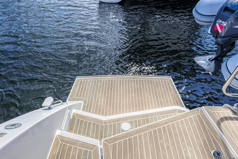  Yacht Photos Pics Stern view of 2020 Leopard 45 boat with wooden deck and outboard motor.