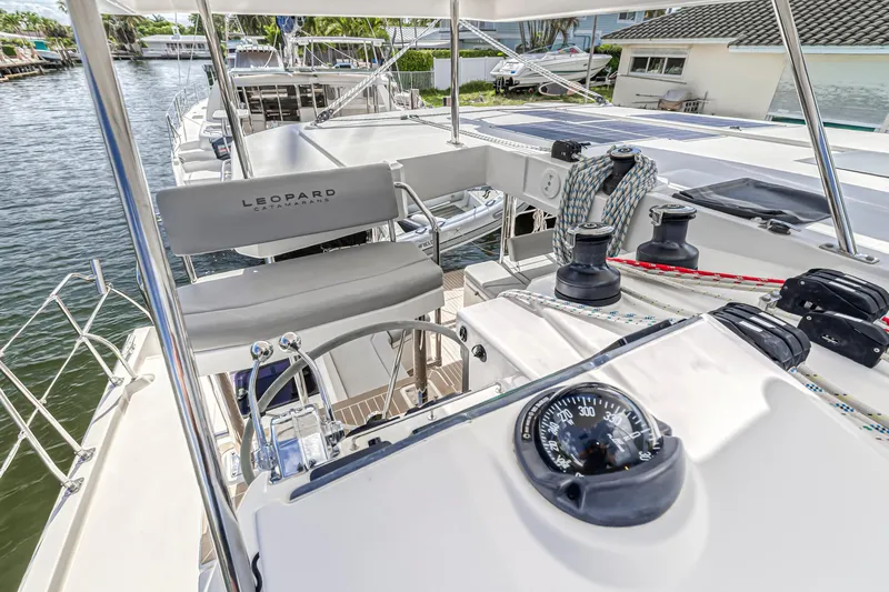  Yacht Photos Pics 2020 Leopard 45 catamaran helm with navigation instruments and seating, docked by the water.