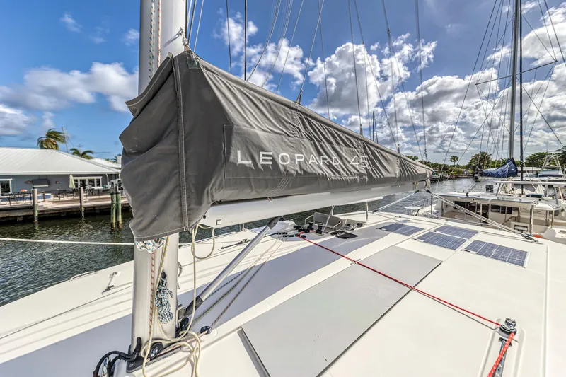  Yacht Photos Pics 2020 Leopard 45 catamaran docked, featuring covered sail and clear blue sky.