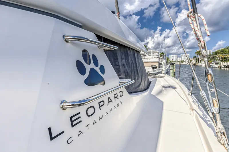  Yacht Photos Pics 2020 Leopard 45 catamaran docked, featuring logo and sleek design under a blue sky.