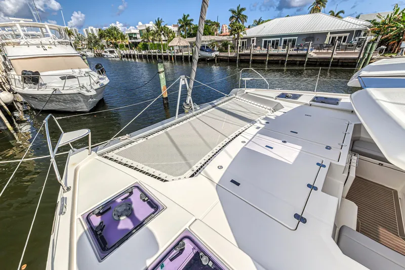  Yacht Photos Pics 2020 Leopard 45 catamaran docked in a marina, featuring spacious deck and netting.
