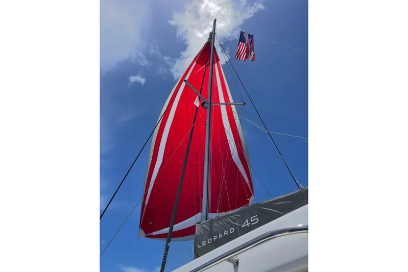  Yacht Photos Pics Red sail on a 2020 Leopard 45 catamaran against a clear blue sky.