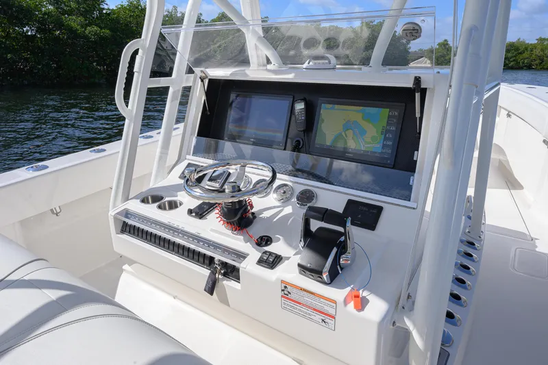  Yacht Photos Pics 2025 SeaVee 370Z boat console with navigation screens and controls on a sunny day.