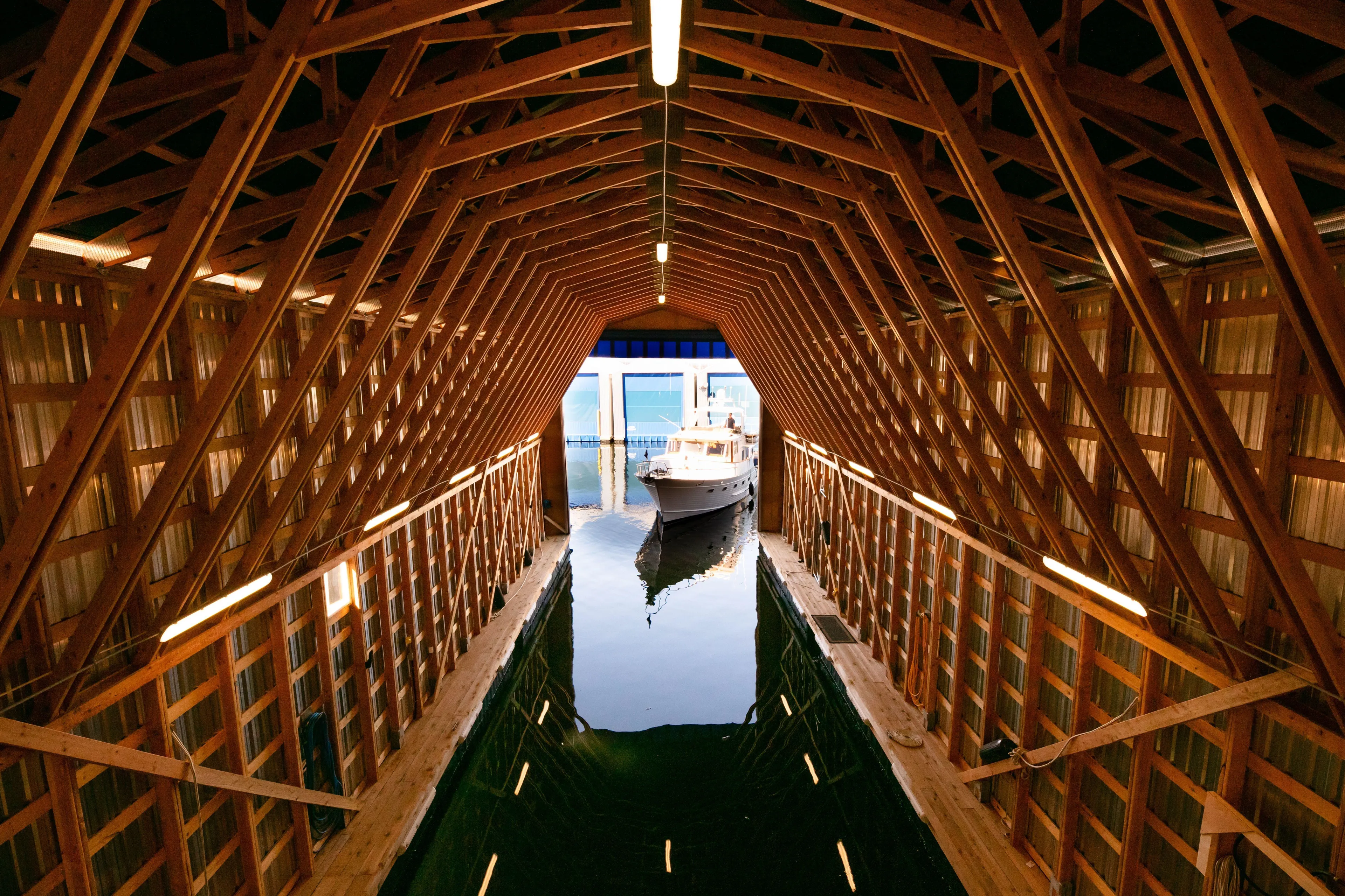  Yacht Photos Pics Custom OBMG Boathouse 95, 2025 model, docked inside a wooden boathouse.