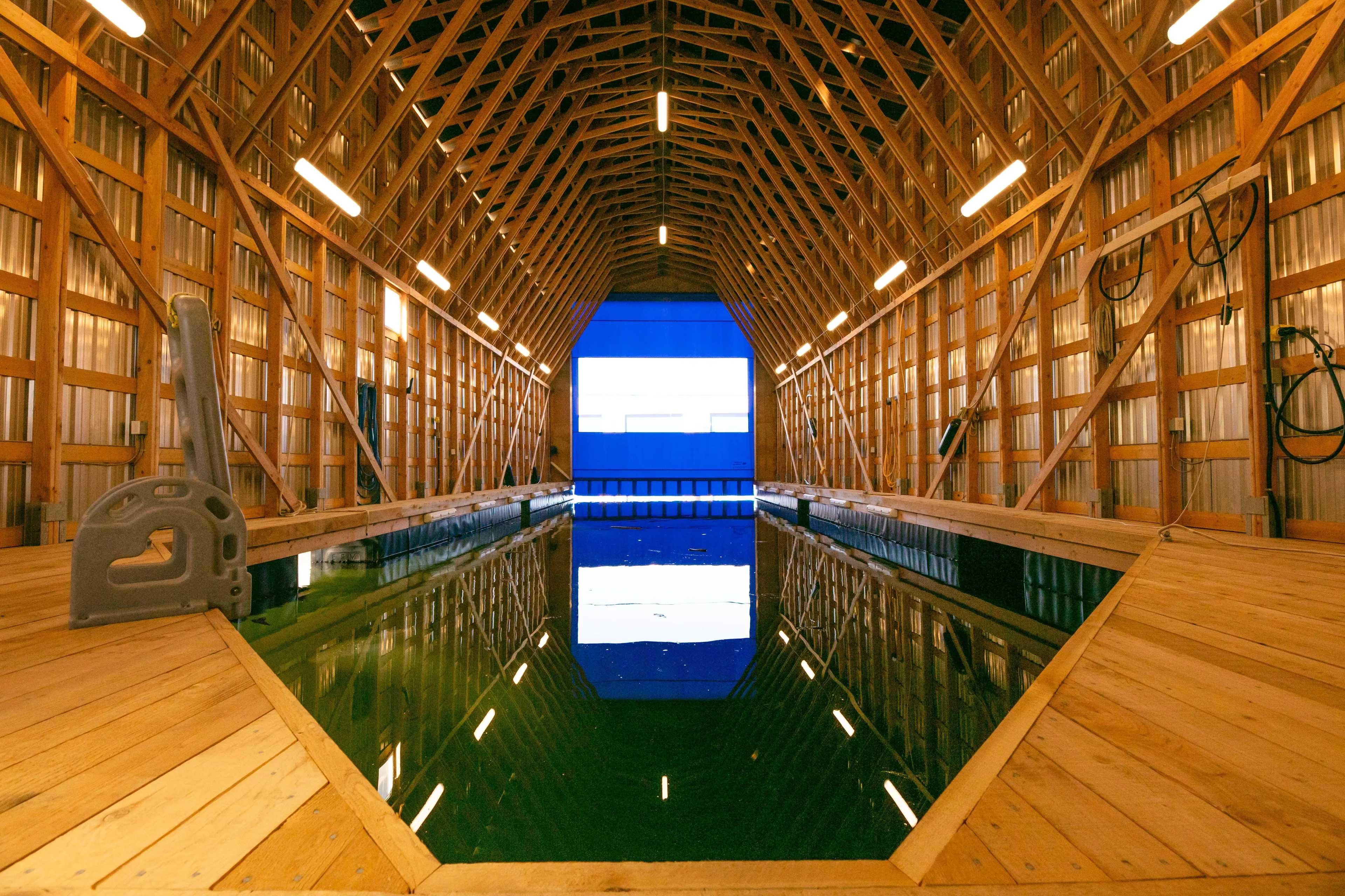  Yacht Photos Pics Interior of Custom OBMG Boathouse 95, 2025, featuring wooden structure and water channel.