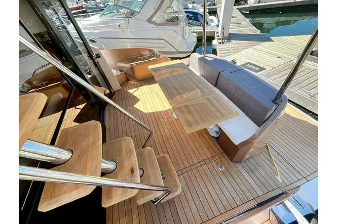  Yacht Photos Pics Luxurious 2025 Sessa Marine F47 yacht with elegant wooden deck and seating area.