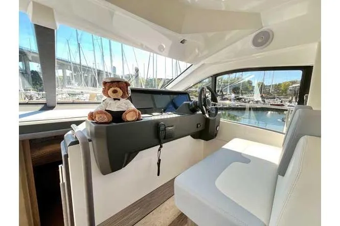  Yacht Photos Pics 2025 Sessa Marine F47 yacht interior with teddy bear on dashboard, marina view.