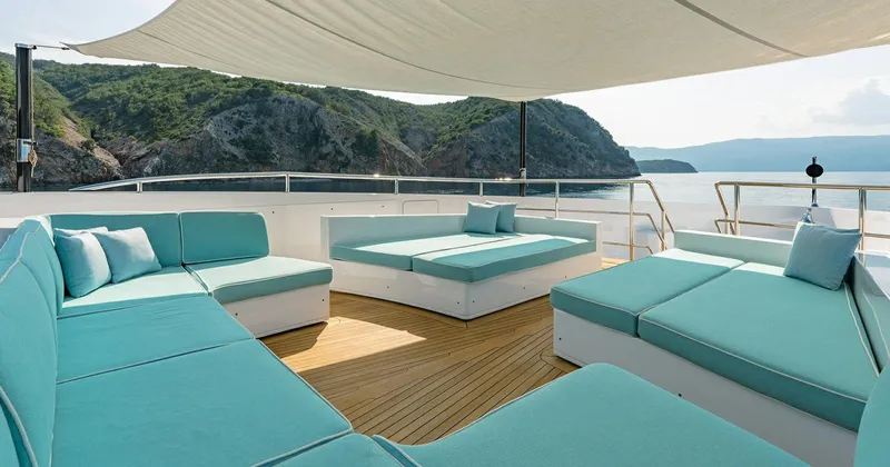  Yacht Photos Pics Luxurious Benetti Seagull 2020 yacht deck with turquoise seating, scenic ocean and mountain views.