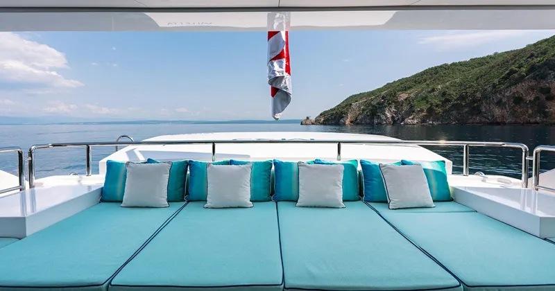  Yacht Photos Pics Luxurious 2020 Benetti Seagull yacht deck with turquoise seating, ocean view, and coastal backdrop.