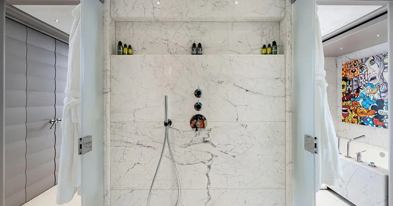  Yacht Photos Pics Luxurious marble shower in 2020 Benetti Seagull yacht bathroom, featuring modern fixtures and vibrant artwork.