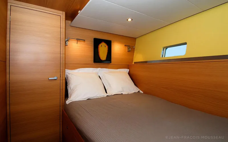 Whimsy Yacht Photos Pics Luxurious cabin interior of 2005 Vaudrey Miller yacht, featuring cozy bed and modern decor.