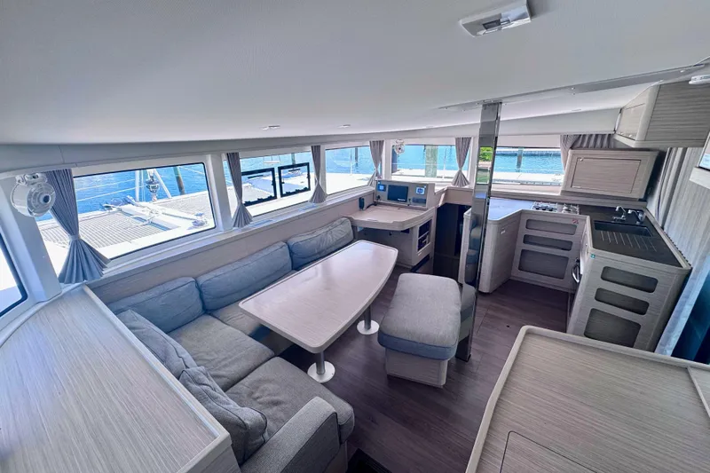  Yacht Photos Pics Interior of 2024 Lagoon 42 catamaran with modern seating and kitchen area.