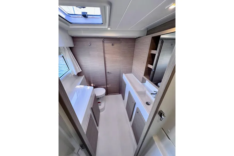 Yacht Photos Pics 2024 Lagoon 42 yacht bathroom with modern fixtures and skylight.