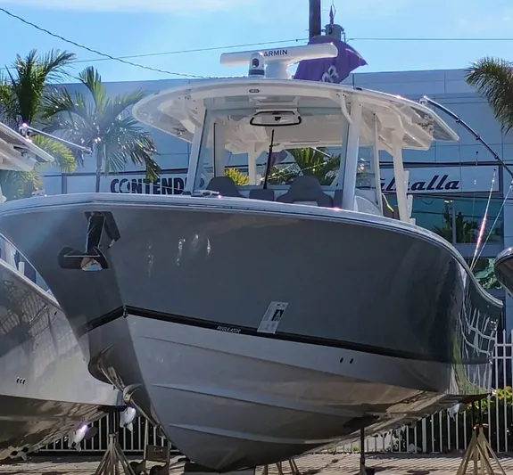 Yacht Photos Pics 2024 Regulator 37 boat displayed outdoors with palm trees and building in background.