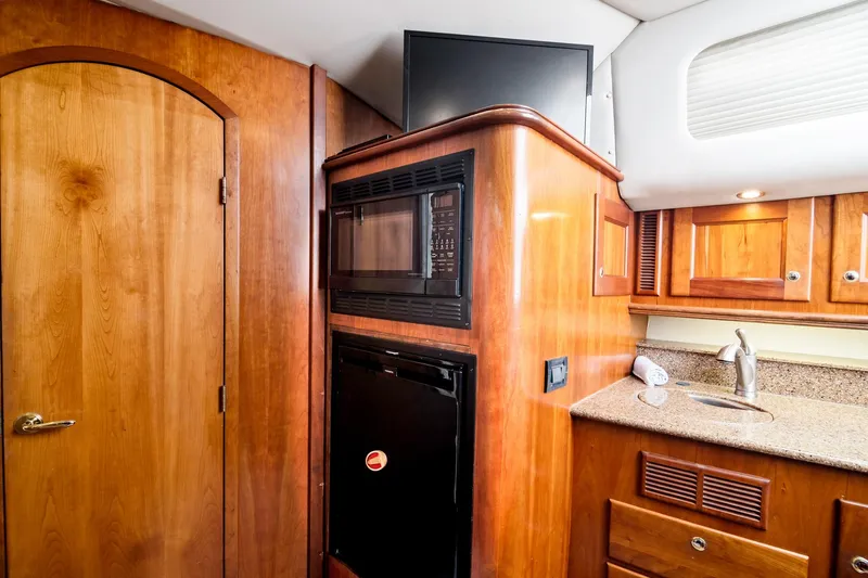 Lilli Ann Yacht Photos Pics 2001 Rampage 38 Express yacht interior with wood cabinetry, microwave, and sink.