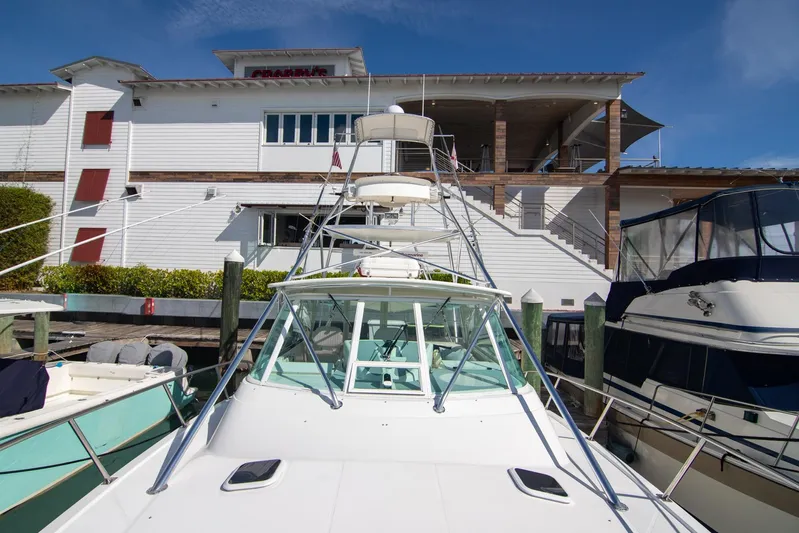 Lilli Ann Yacht Photos Pics 2001 Rampage 38 Express yacht docked near a white building under clear blue skies.