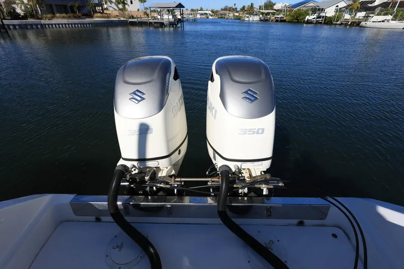  Yacht Photos Pics Twin Suzuki 350 outboard engines on a 2005 Jupiter 38 FS boat, docked in a serene marina.