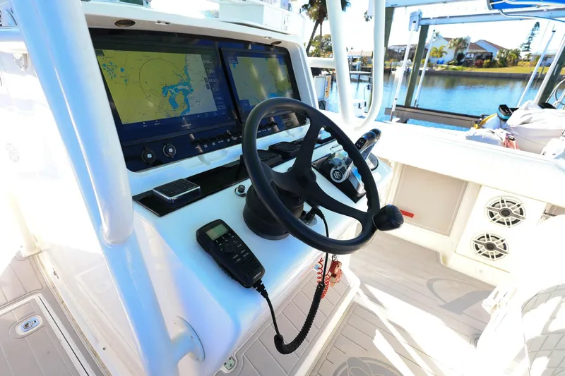  Yacht Photos Pics 2005 Jupiter 38 FS boat cockpit with navigation screens and steering wheel.