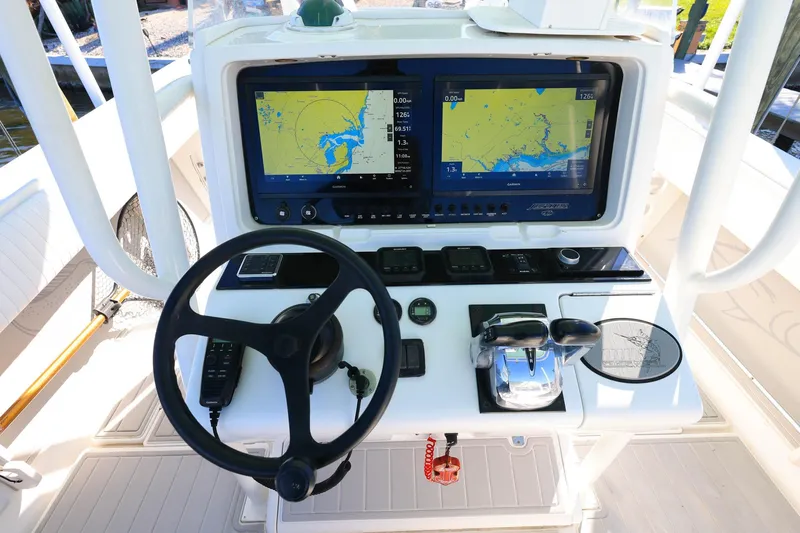  Yacht Photos Pics Control panel of a 2005 Jupiter 38 FS boat with navigation screens and steering wheel.