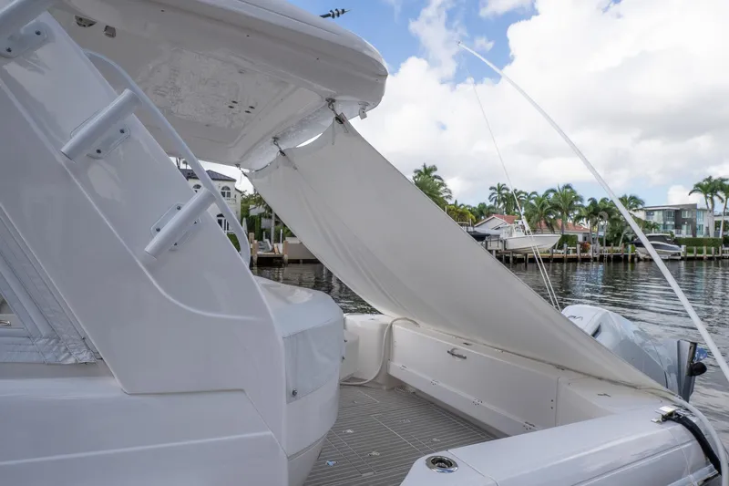 Garbonzo Yacht Photos Pics Intrepid 477 Evolution 2022 yacht with sunshade, docked by waterfront homes.