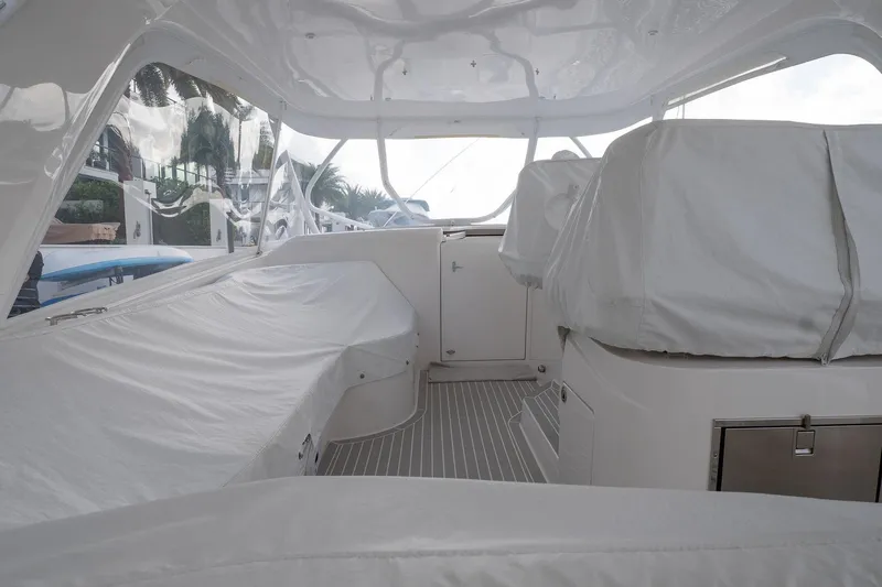 Garbonzo Yacht Photos Pics Interior view of 2022 Intrepid 477 Evolution yacht, featuring covered seating and sleek design.