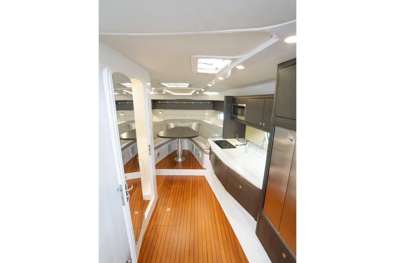 Garbonzo Yacht Photos Pics Luxurious interior of 2022 Intrepid 477 Evolution yacht with modern kitchen and seating area.