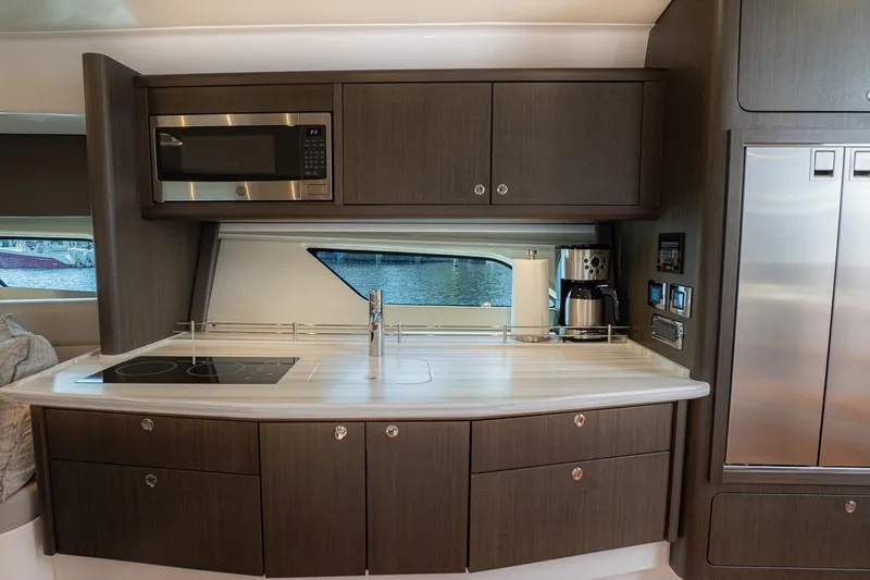 Garbonzo Yacht Photos Pics Modern kitchen interior of 2022 Intrepid 477 Evolution yacht with sleek appliances and cabinetry.