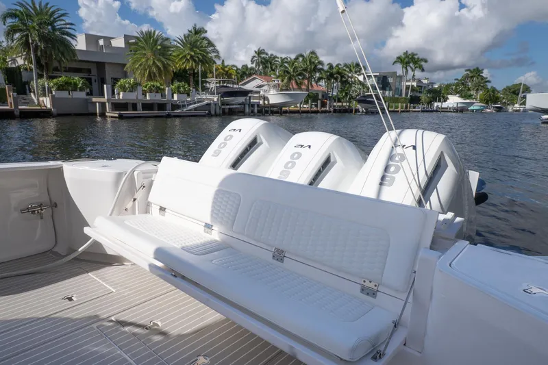 Garbonzo Yacht Photos Pics 2022 Intrepid 477 Evolution boat with triple outboard engines, docked by palm trees.