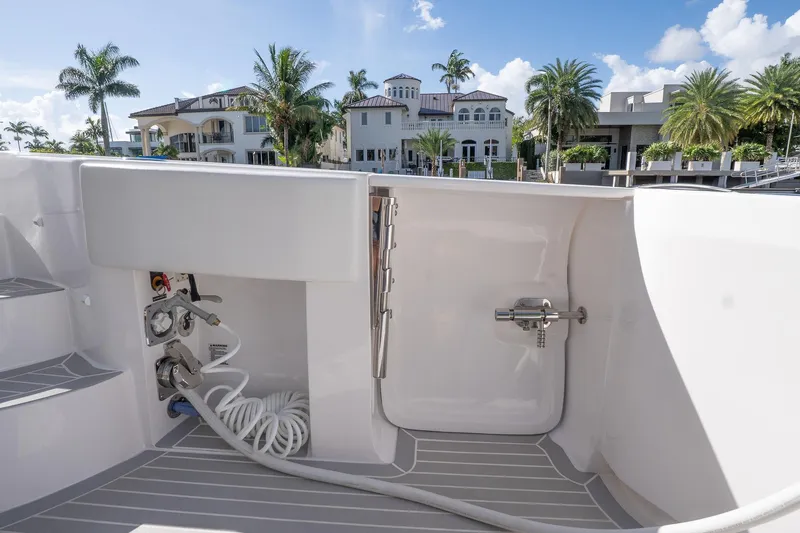 Garbonzo Yacht Photos Pics 2022 Intrepid 477 Evolution boat deck with hose and luxury waterfront view.