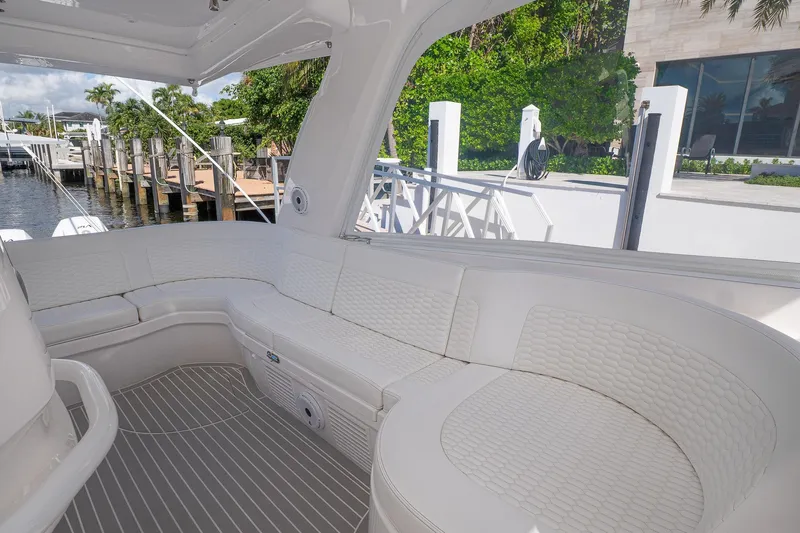 Garbonzo Yacht Photos Pics Luxurious seating area on a 2022 Intrepid 477 Evolution yacht, docked by a waterfront.