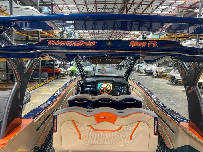 Thunder Struck Yacht Photos Pics 2024 MTI V42 boat interior with orange and white seating, located in a warehouse.