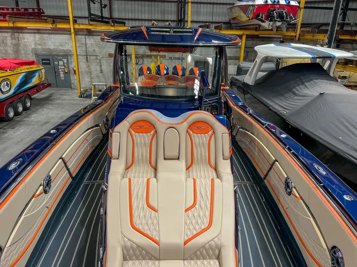 Thunder Struck Yacht Photos Pics 2024 MTI V42 boat with luxurious seating and sleek design in a showroom.