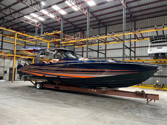 Thunder Struck Yacht Photos Pics 2024 MTI V42 boat with sleek design in a warehouse setting.