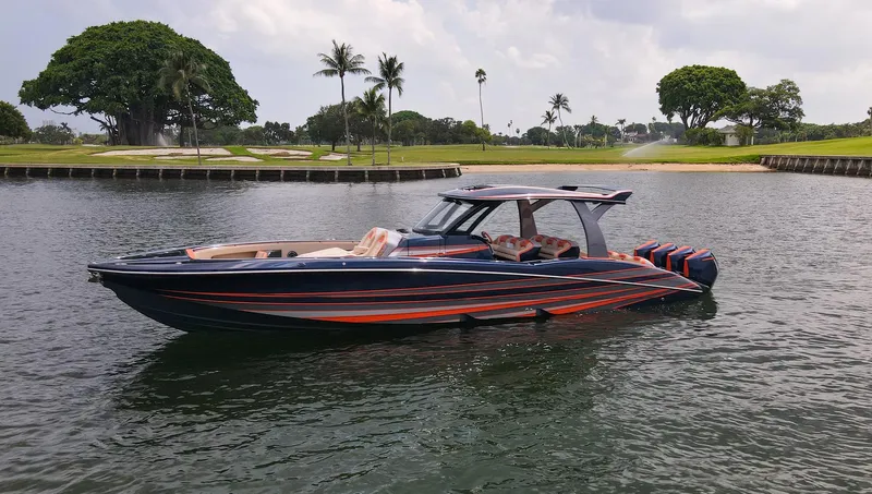 Thunder Struck Yacht Photos Pics 2024 MTI V42 boat on water, sleek design, vibrant colors, tropical background.