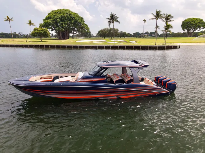 Thunder Struck Yacht Photos Pics 2024 MTI V42 boat with sleek design, vibrant colors, cruising on a calm waterway.