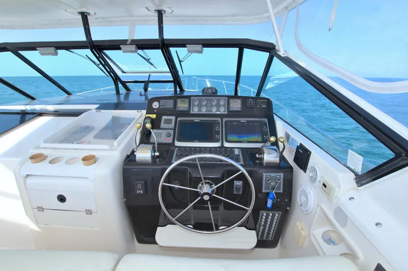 Ohana Yacht Photos Pics 2003 Tiara Yachts 4000 Express helm with ocean view, featuring navigation equipment and steering wheel.