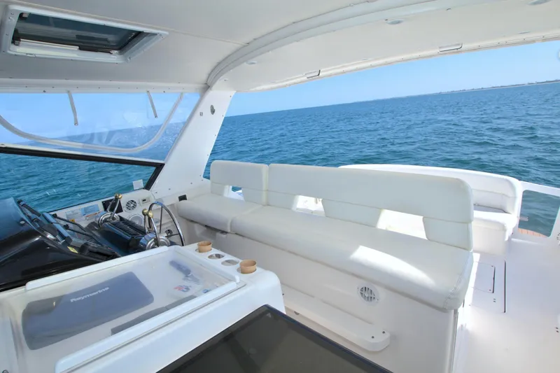 Ohana Yacht Photos Pics 2003 Tiara Yachts 4000 Express interior with ocean view, featuring white seating and helm controls.