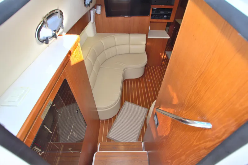 Ohana Yacht Photos Pics 2003 Tiara Yachts 4000 Express interior with curved seating and wooden flooring.