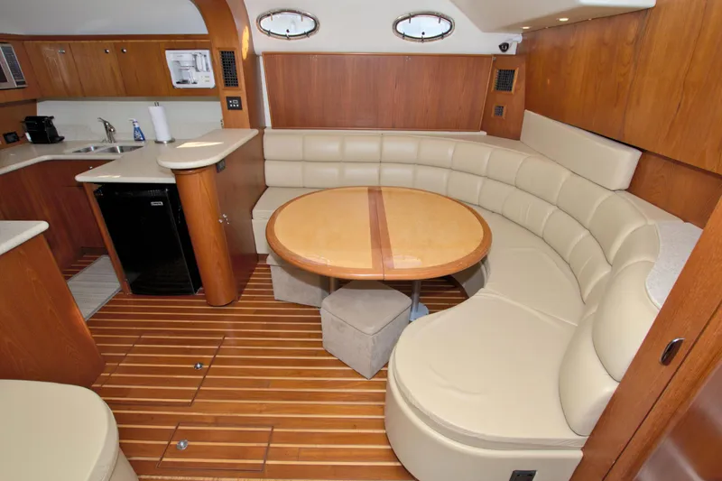 Ohana Yacht Photos Pics Luxurious 2003 Tiara Yachts 4000 Express interior with curved seating and wooden accents.