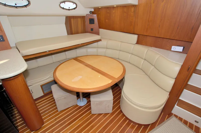 Ohana Yacht Photos Pics 2003 Tiara Yachts 4000 Express interior with curved seating and wooden table.