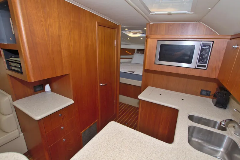 Ohana Yacht Photos Pics 2003 Tiara Yachts 4000 Express interior with kitchen, microwave, and wooden cabinetry.