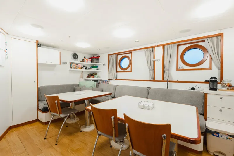 Were Dreams Yacht Photos Pics Cozy dining area on 2008 Amels 171 Limited Edition yacht with porthole windows and modern decor.