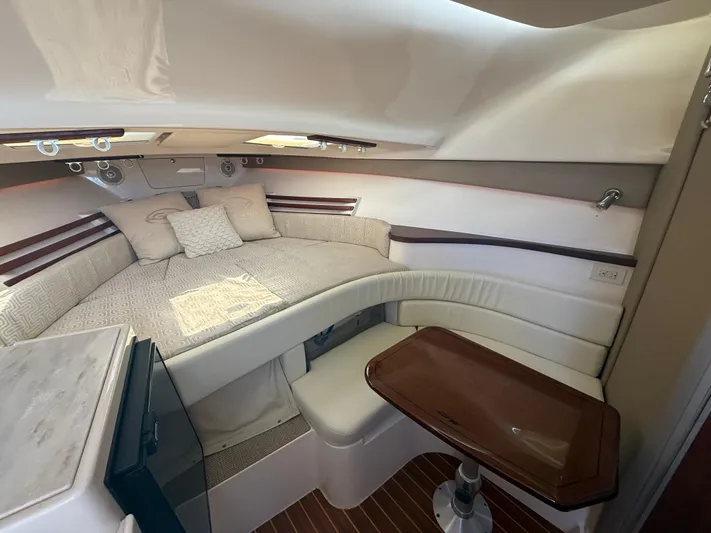  Yacht Photos Pics 2016 Grady-White Express 330 cabin interior with cozy seating and wooden table.