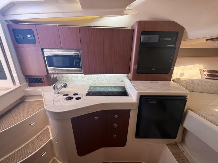  Yacht Photos Pics 2016 Grady-White Express 330 boat interior kitchen with microwave, stove, and fridge.