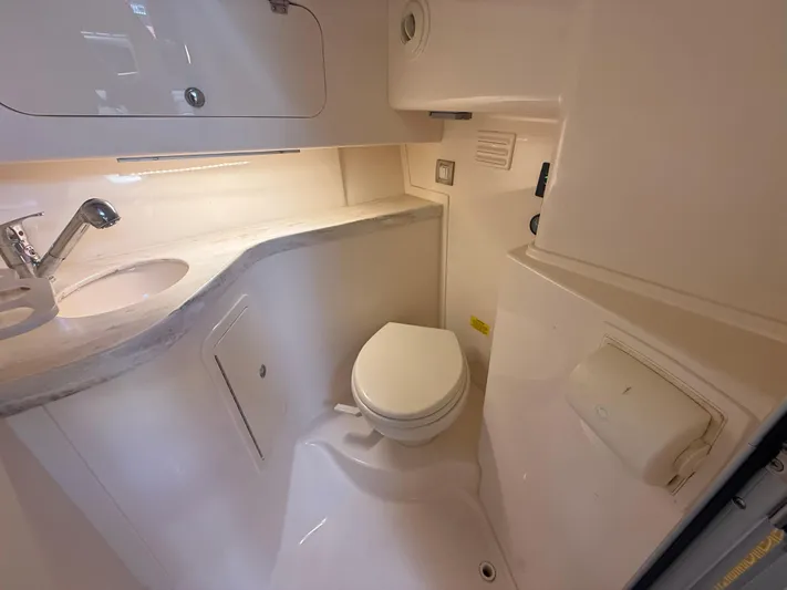  Yacht Photos Pics 2016 Grady-White Express 330 boat bathroom with sink, toilet, and storage cabinets.
