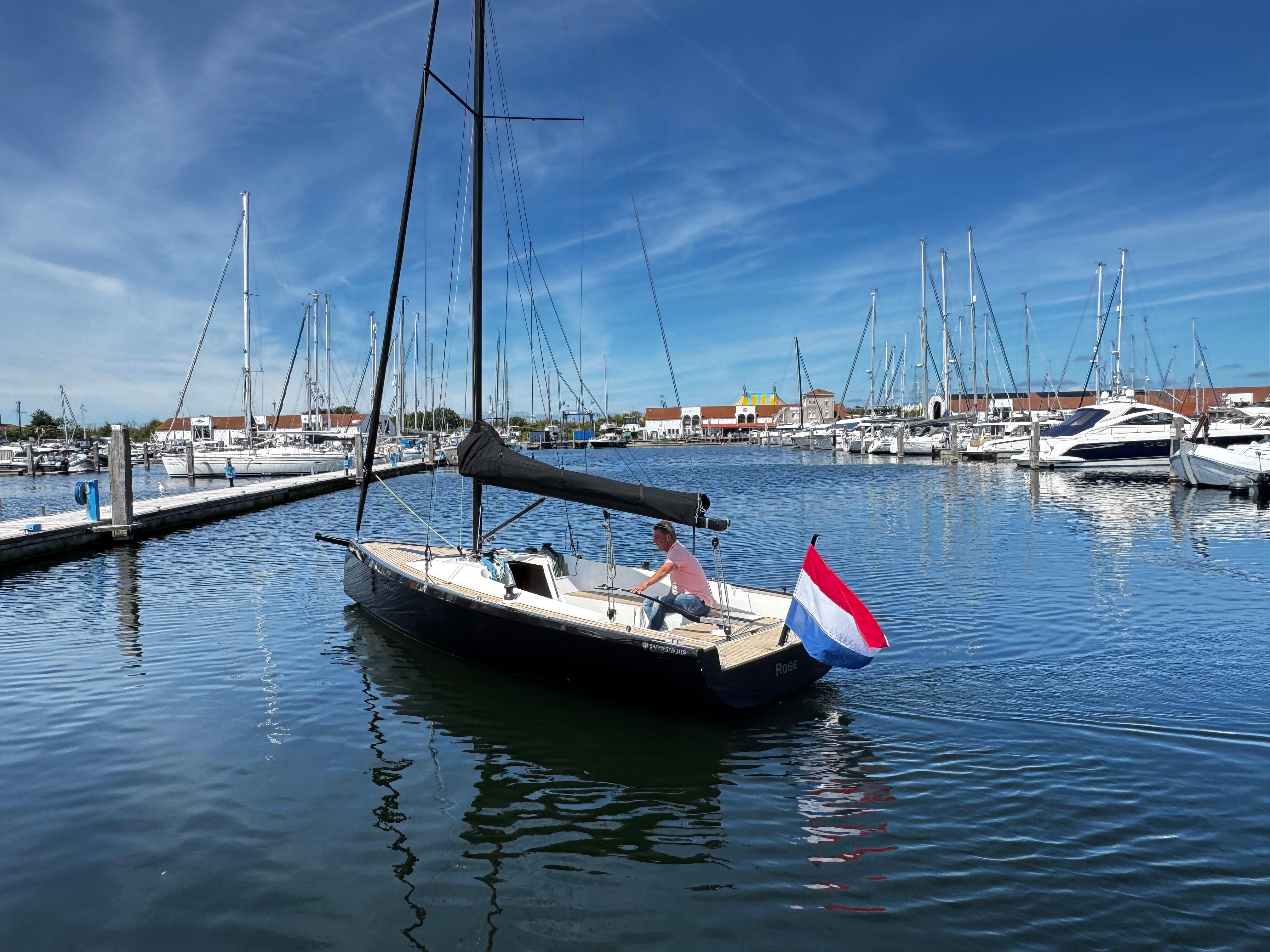 2023 Saffier SE 24 Lite sailboat in marina, Dutch flag, clear blue sky.