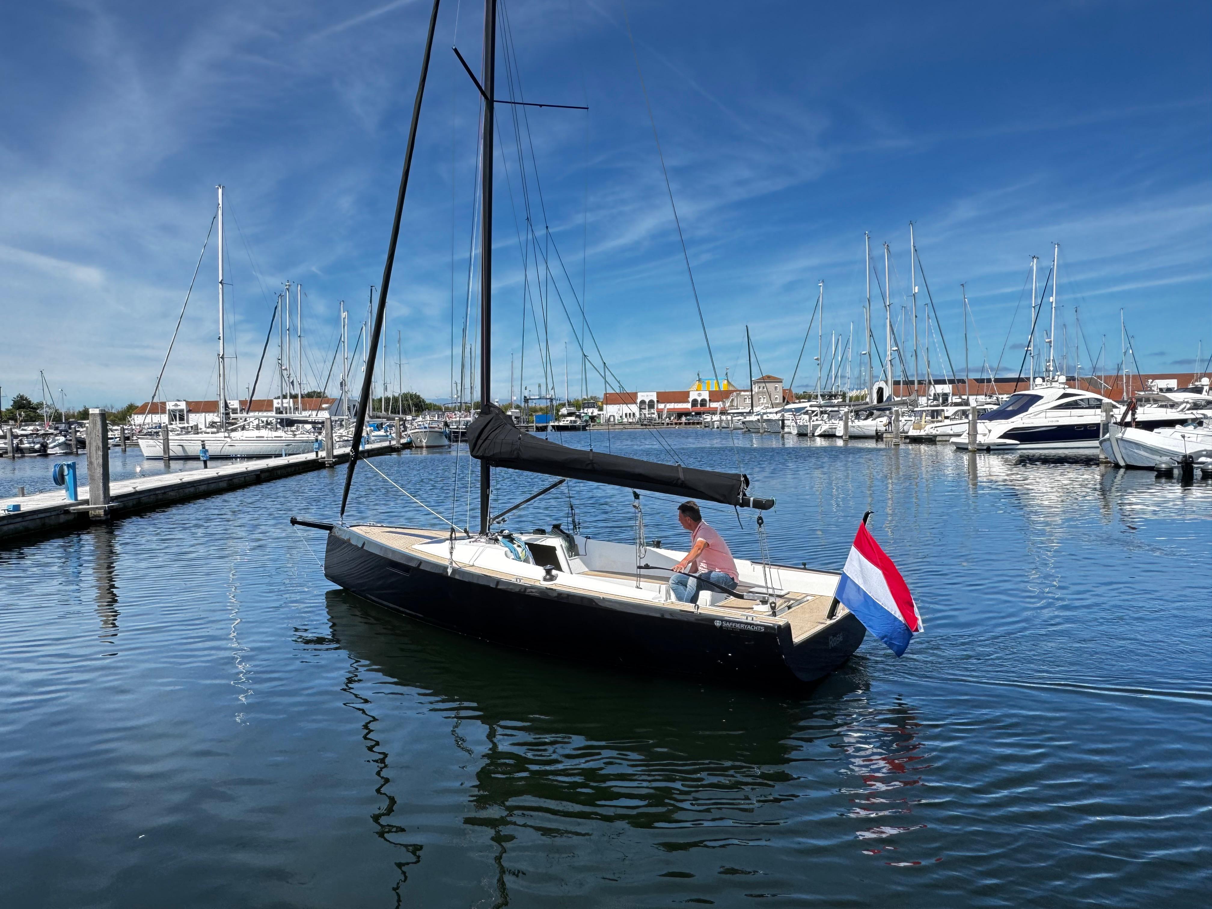 2023 Saffier SE 24 Lite sailboat in marina, Dutch flag, clear blue sky.