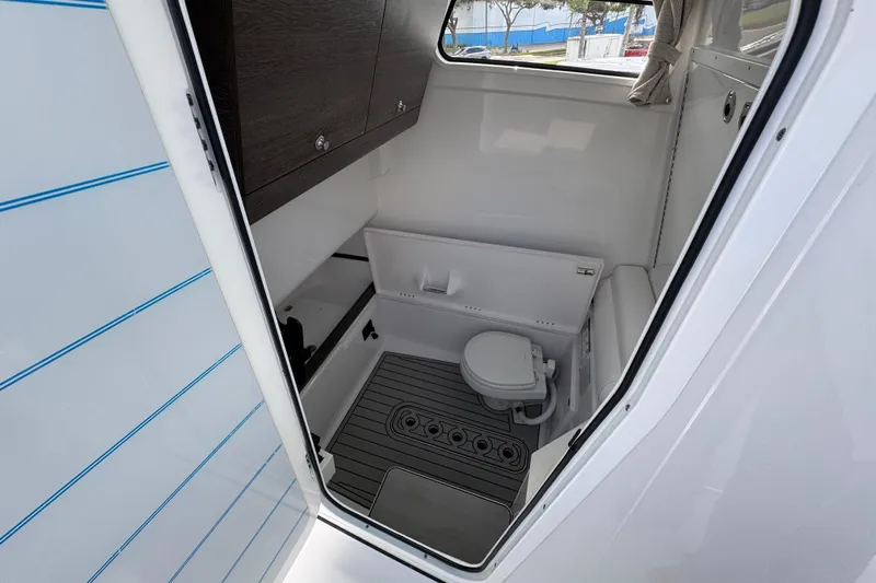  Yacht Photos Pics 2025 Sportsman Open 302 Center Console boat interior with compact marine toilet.