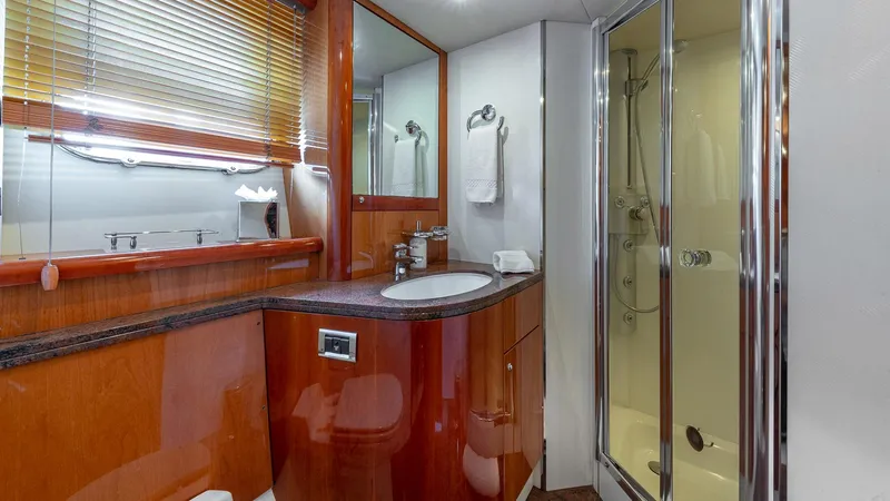 Iconic Yacht Photos Pics Luxurious bathroom in 2003 Sunseeker 82 Yacht with wood accents and modern fixtures.